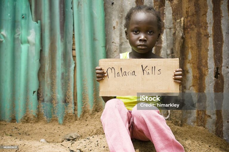 An African girl holding a sign with "Malaria Kills" written on it